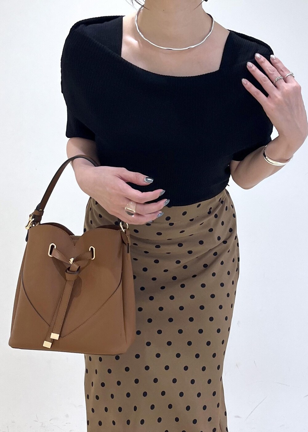 ブラック系のサンダル、ブラウン系のショルダーバッグ、ブラウン系のスカートを着用したレディースの夏コーディネートの6枚目の写真