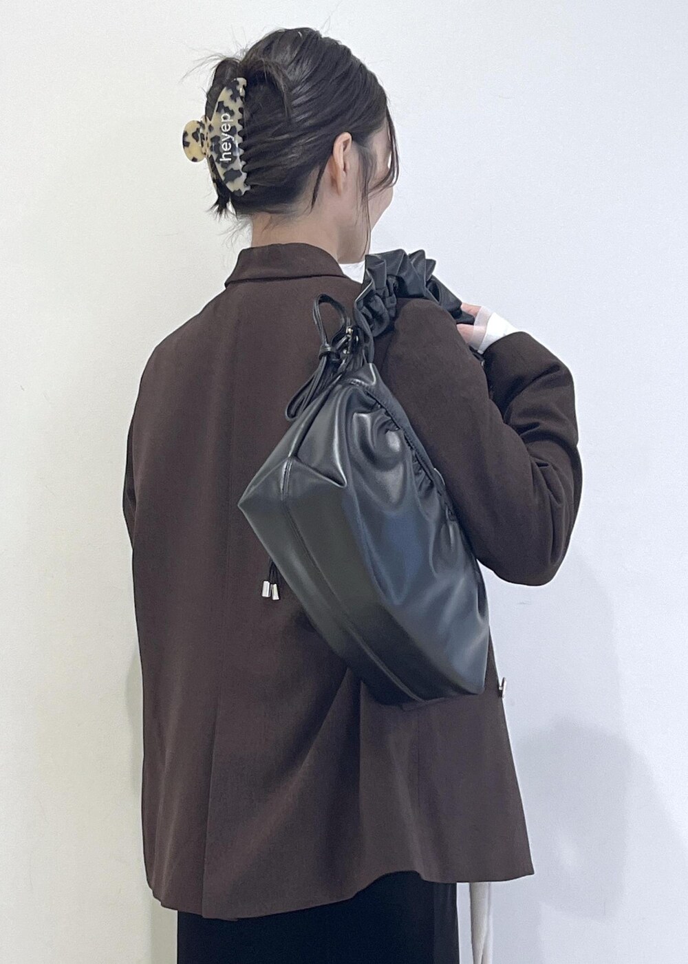 ホワイト系のTシャツ/カットソー、ブラック系のブーツ、ブラック系のスカートを着用したレディースの秋コーディネートの10枚目の写真