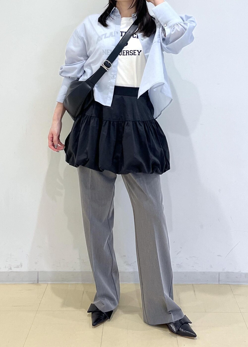 ブラック系のパンプス、ブラック系のスカート、ブルー系のシャツ/ブラウスを着用したレディースの春コーディネートの2枚目の写真