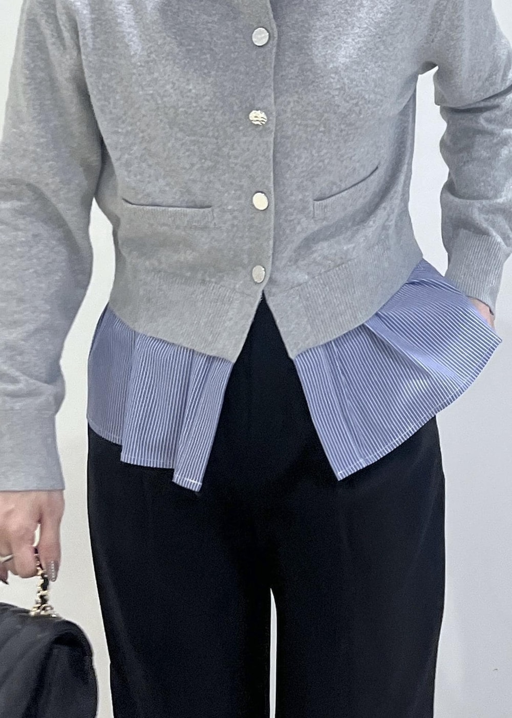 ホワイト系のパンプス、グレー系のカーディガン/ボレロ、ブラック系のスラックスを着用したレディースの冬コーディネートの7枚目の写真