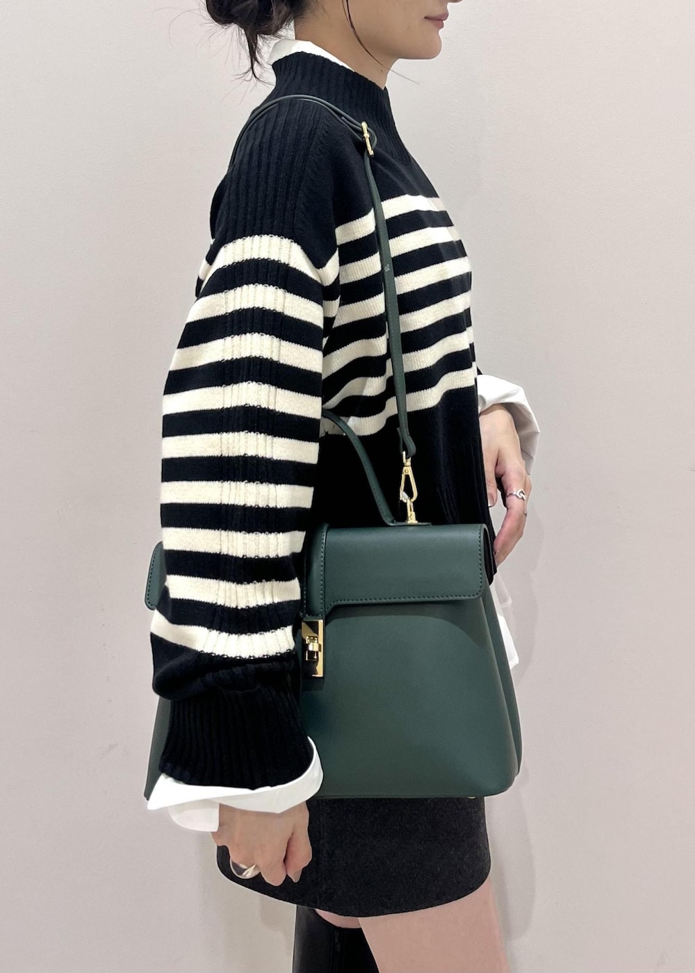 ブラック系のブーツ、ホワイト系のシャツ/ブラウス、ブラック系のニット/セーターを着用したレディースの秋コーディネートの10枚目の写真