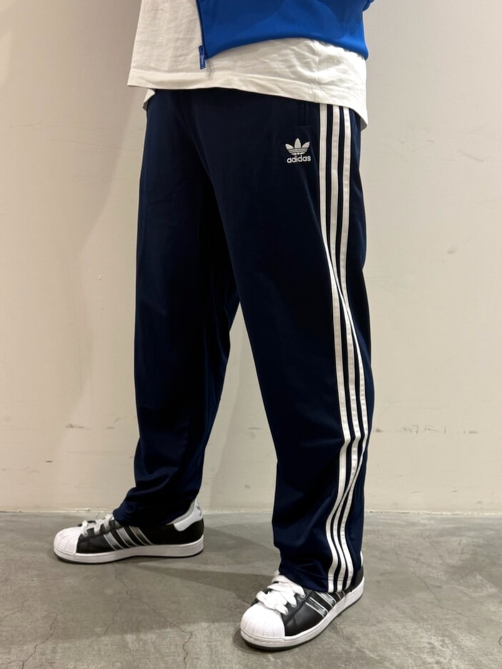 ブルー系のジャージ、ホワイト系のTシャツ/カットソー、ブラック系のスニーカーを着用したメンズの秋コーディネートの4枚目の写真