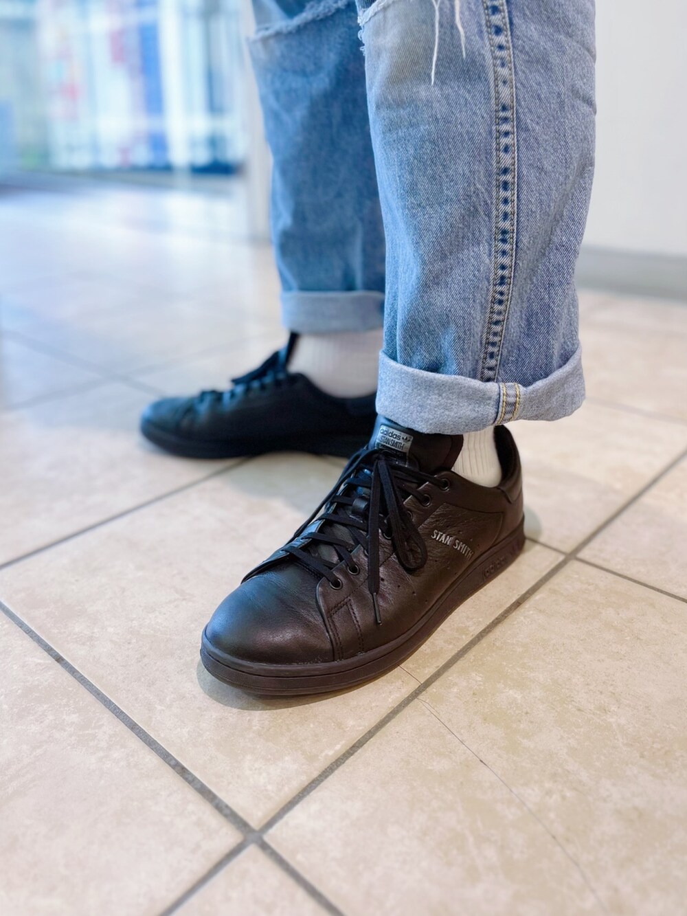 ブルー系のTシャツ/カットソー、ブラック系のスニーカーを着用したメンズの春コーディネートの4枚目の写真