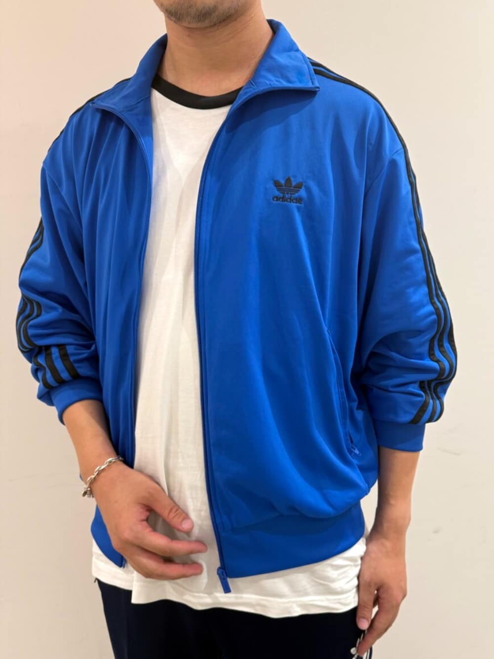 ブルー系のジャージ、ホワイト系のTシャツ/カットソー、ブラック系のスニーカーを着用したメンズの秋コーディネートの3枚目の写真