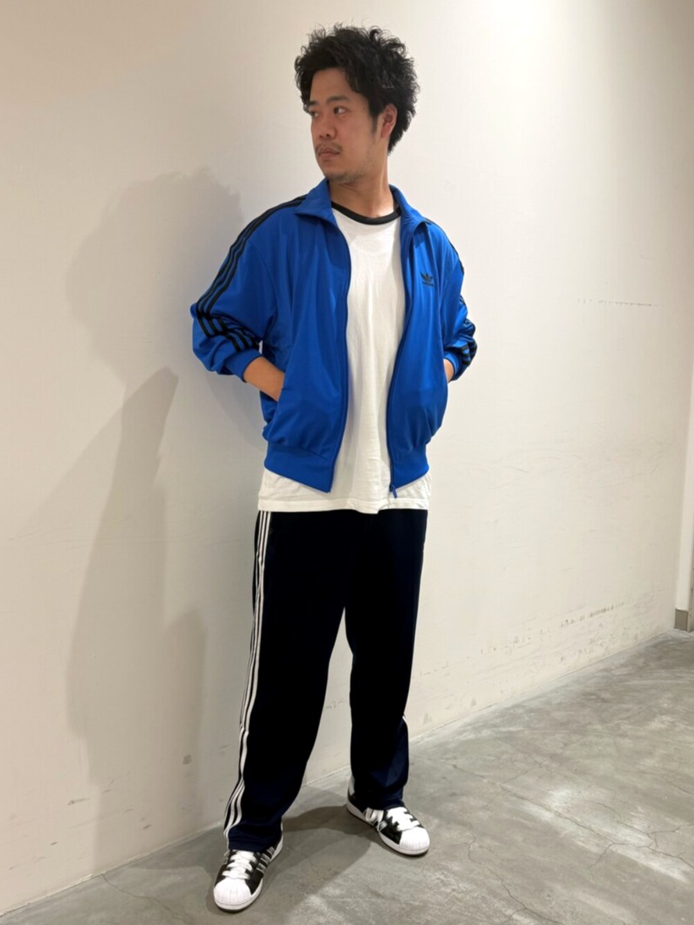 ブルー系のジャージ、ホワイト系のTシャツ/カットソー、ブラック系のスニーカーを着用したメンズの秋コーディネートの2枚目の写真