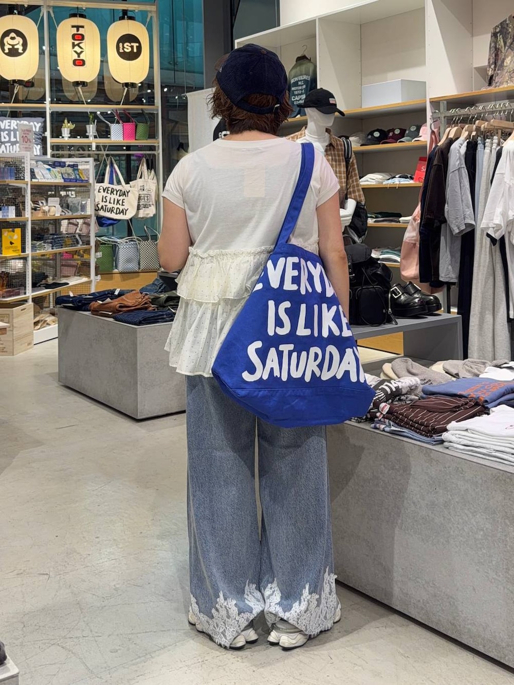 ベージュ系のTシャツ/カットソー、ブルー系のデニムパンツ、ブルー系のキャップを着用したレディースの秋コーディネートの3枚目の写真