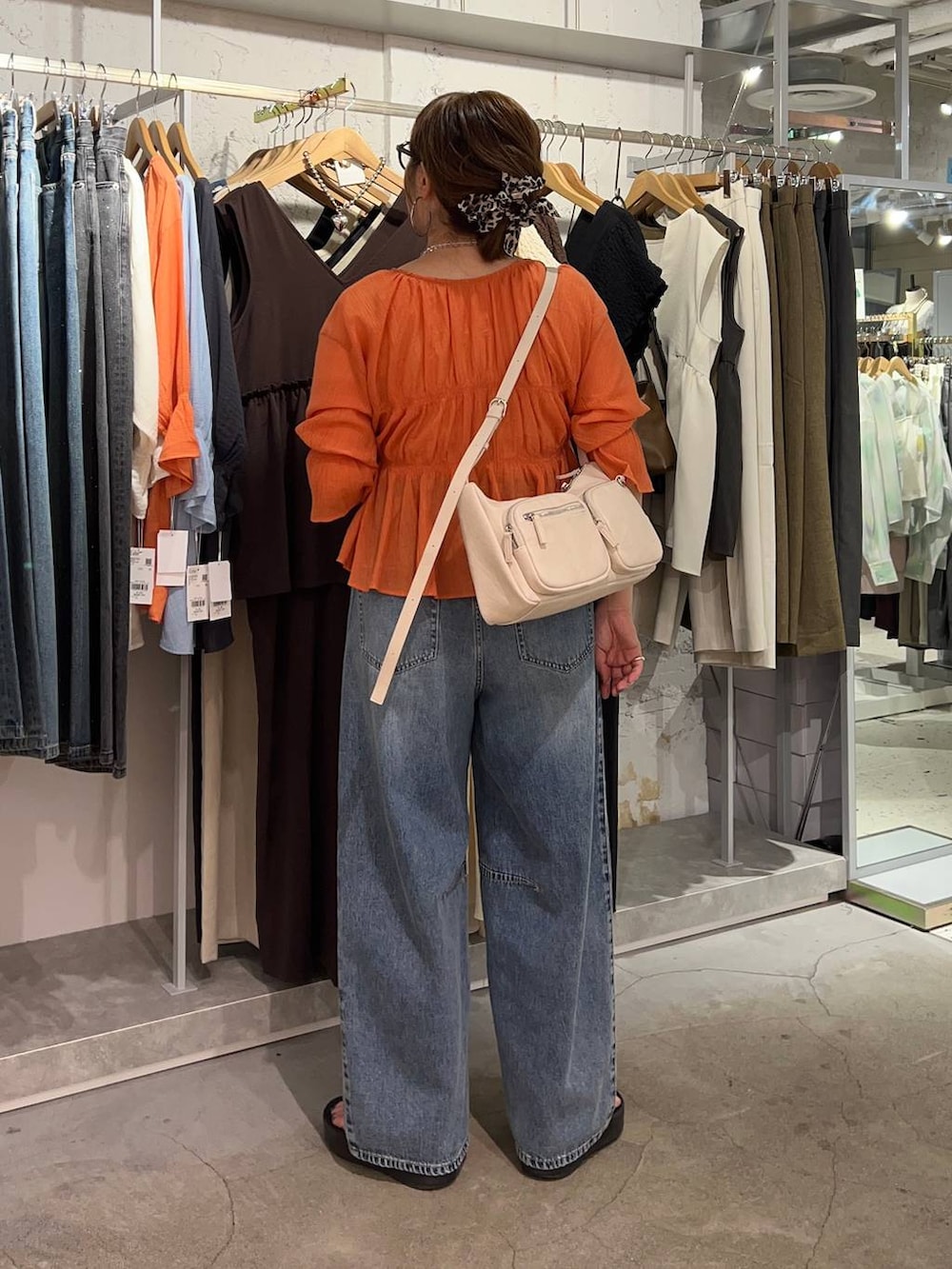 オレンジ系のシャツ/ブラウス、ブルー系のデニムパンツ、ゴールド系のタンクトップを着用したレディースの夏コーディネートの4枚目の写真