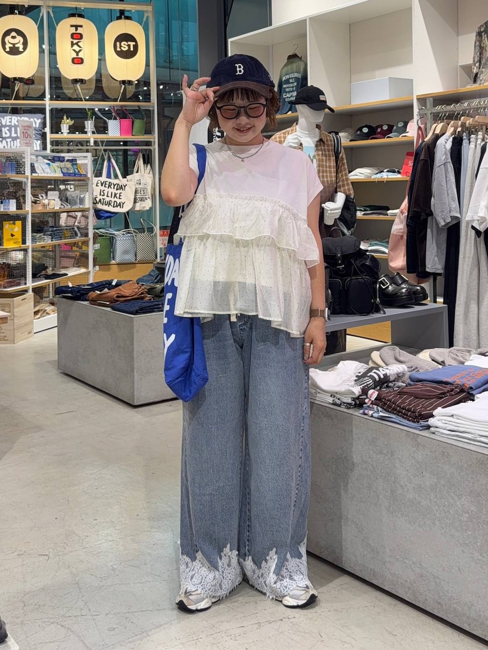 ベージュ系のTシャツ/カットソー、ブルー系のデニムパンツ、ブルー系のキャップを着用したレディースの秋コーディネートの5枚目の写真