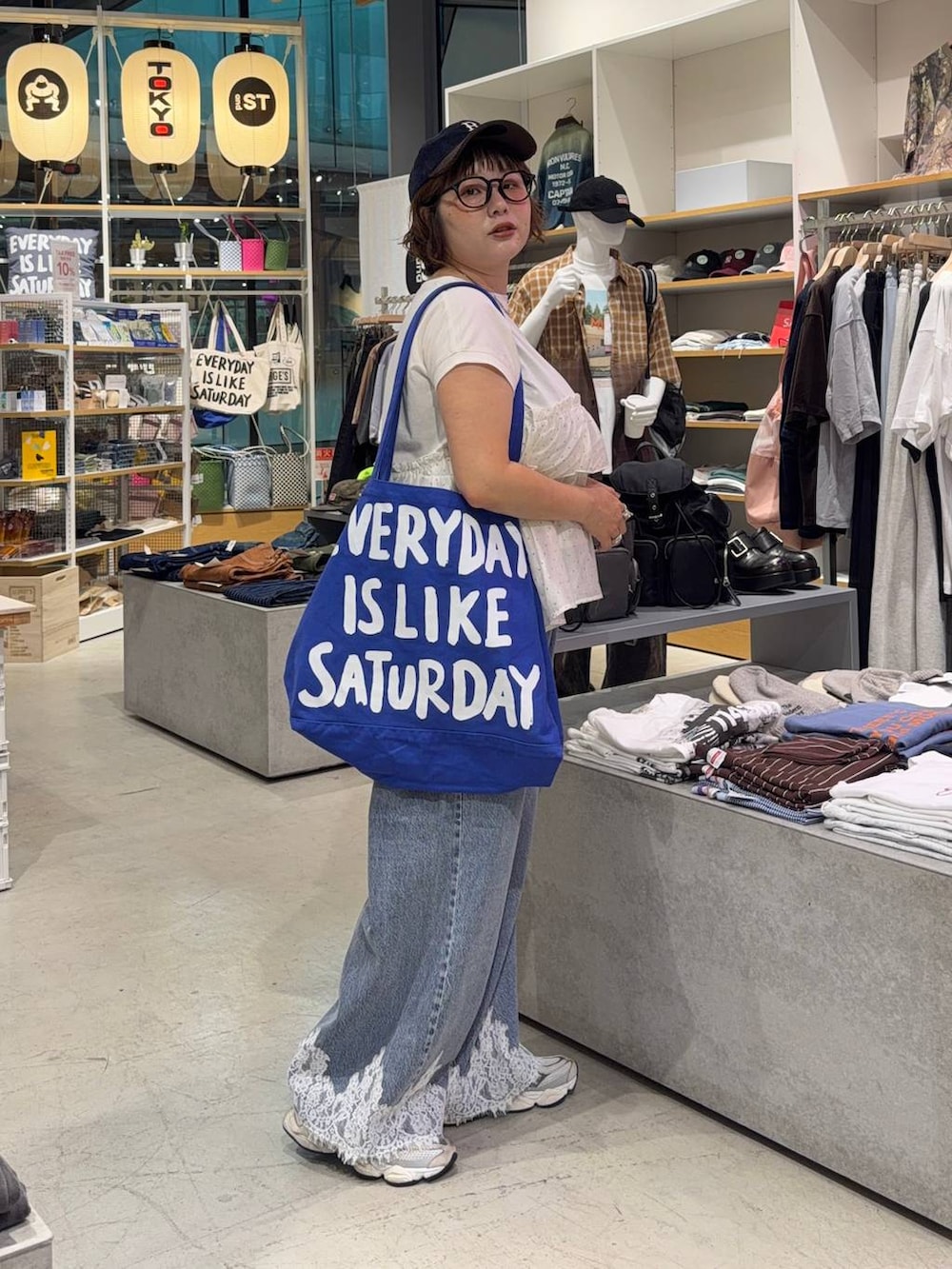 ベージュ系のTシャツ/カットソー、ブルー系のデニムパンツ、ブルー系のキャップを着用したレディースの秋コーディネートの2枚目の写真