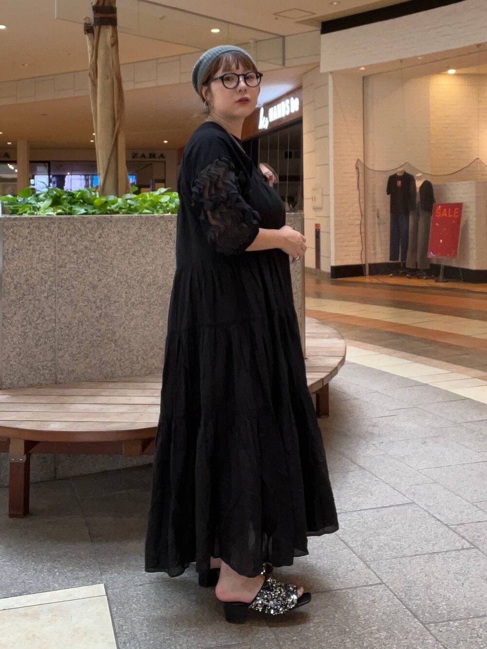 シルバー系のサンダル、ブラック系のワンピース、ブラック系のTシャツ/カットソーを着用したレディースの夏コーディネートの2枚目の写真