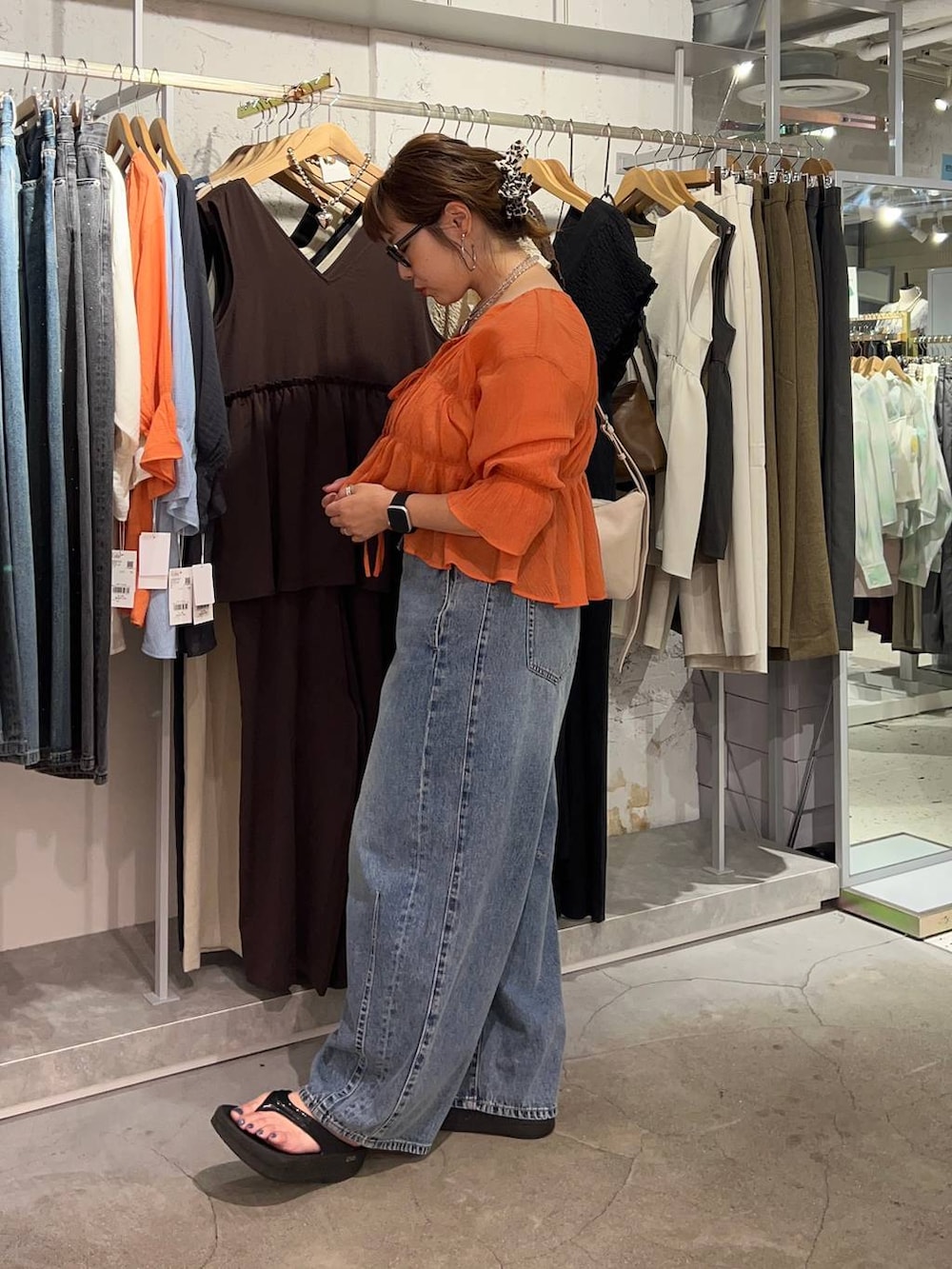 オレンジ系のシャツ/ブラウス、ブルー系のデニムパンツ、ゴールド系のタンクトップを着用したレディースの夏コーディネートの5枚目の写真