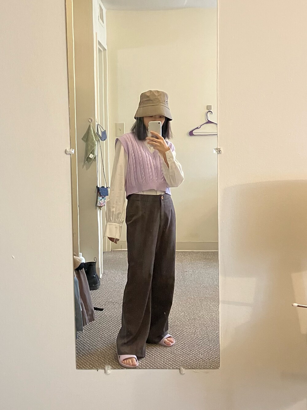 パープル系のベスト、ブラウン系のスラックス、ホワイト系のビジネスシャツを着用したレディースの秋コーディネートの2枚目の写真