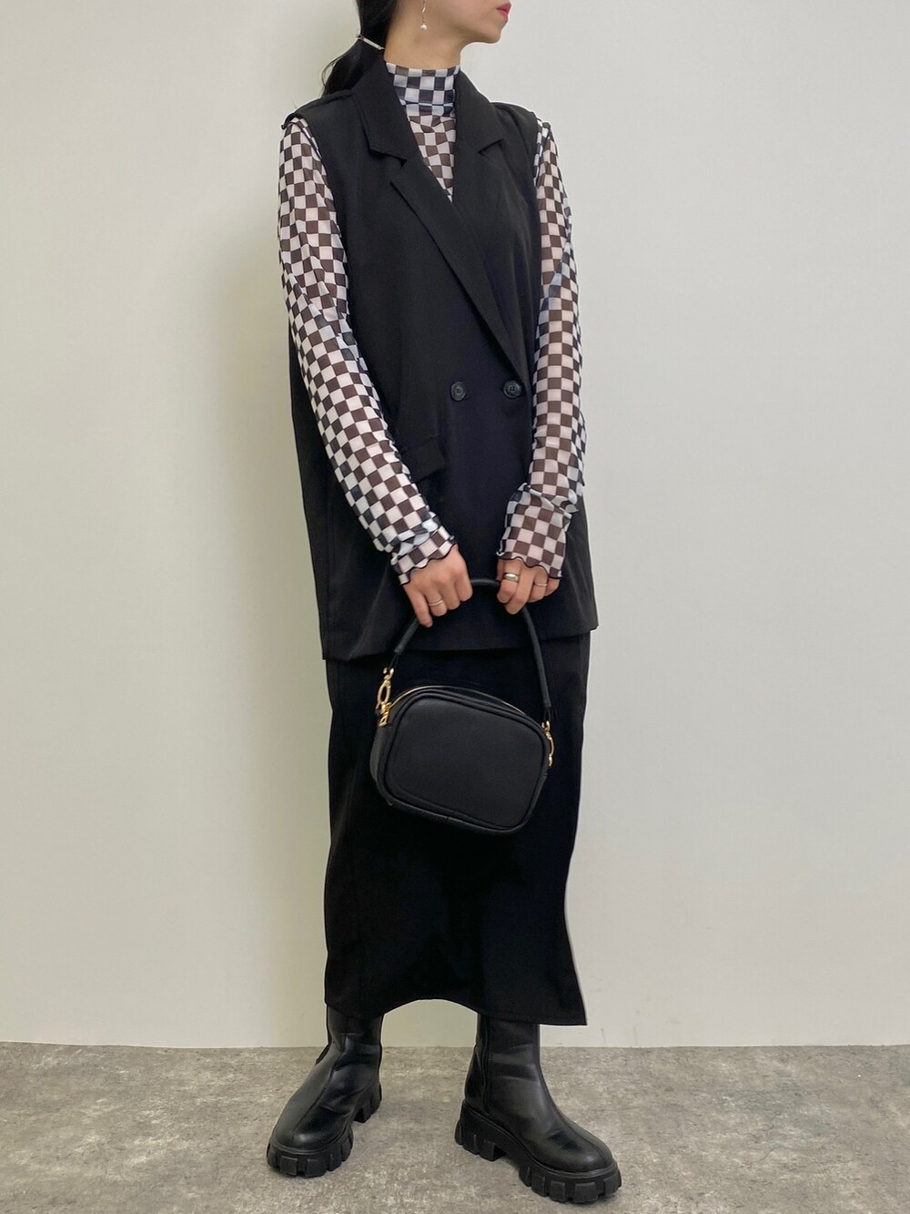 ホワイト系のTシャツ/カットソー、ブラック系のベスト、ブラック系のトートバッグを着用したレディースの春コーディネートの2枚目の写真