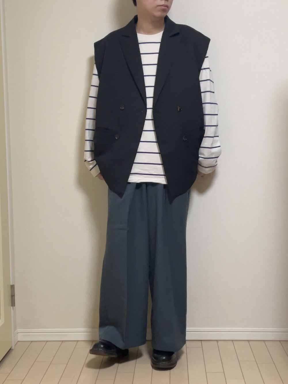 ブラック系のテーラードジャケット、ホワイト系のTシャツ/カットソー、ブルー系のスラックスを着用したメンズの冬コーディネートの2枚目の写真