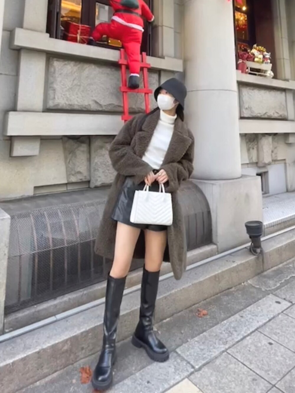 ブラック系のブーツ、ホワイト系のハンドバッグ、ブラック系のその他パンツを着用したレディースの秋コーディネートの2枚目の写真