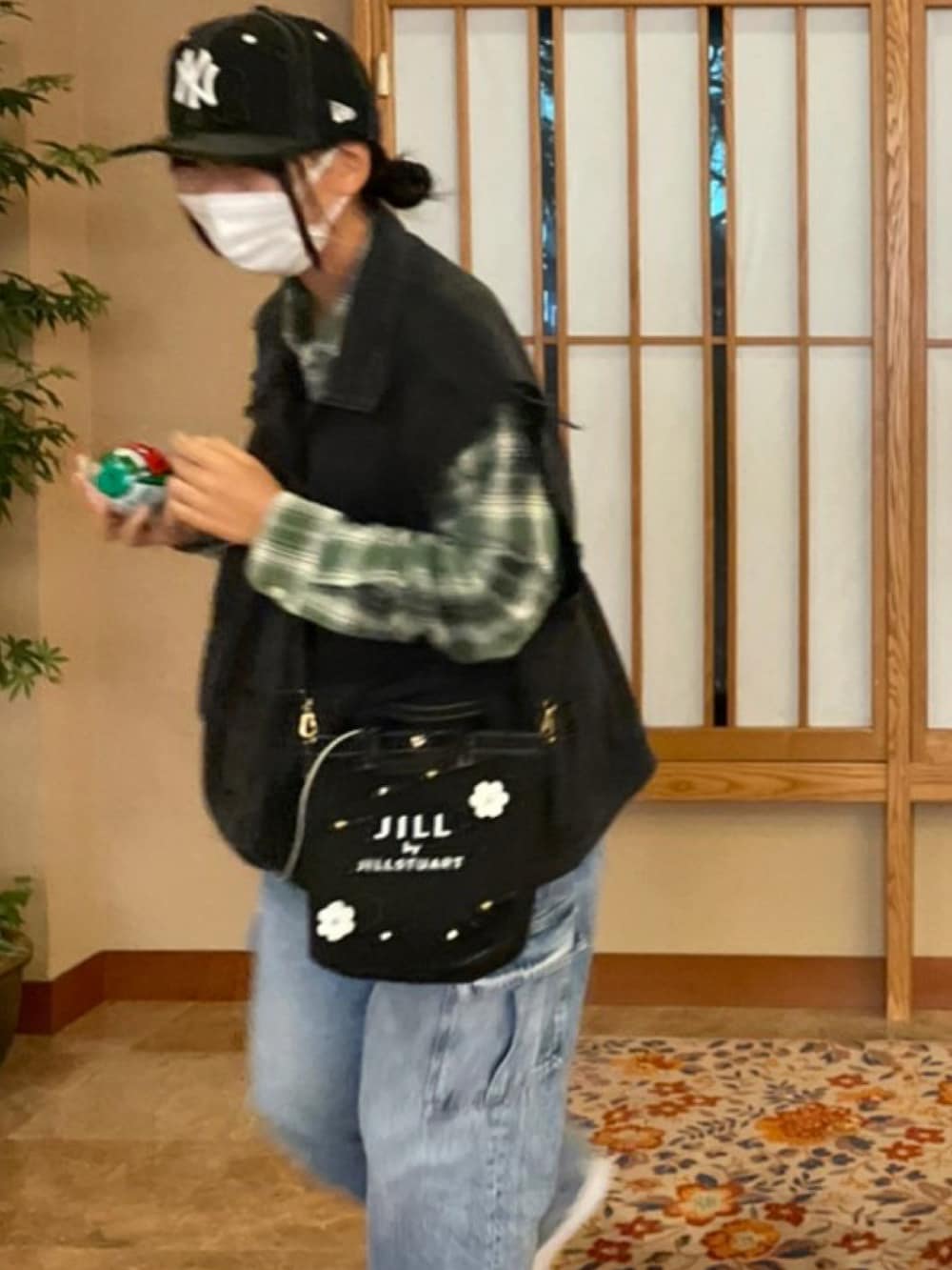 ブルー系のデニムパンツ、ブラック系のジャケット/アウター、ホワイト系のスニーカーを着用したレディースの秋コーディネートの2枚目の写真