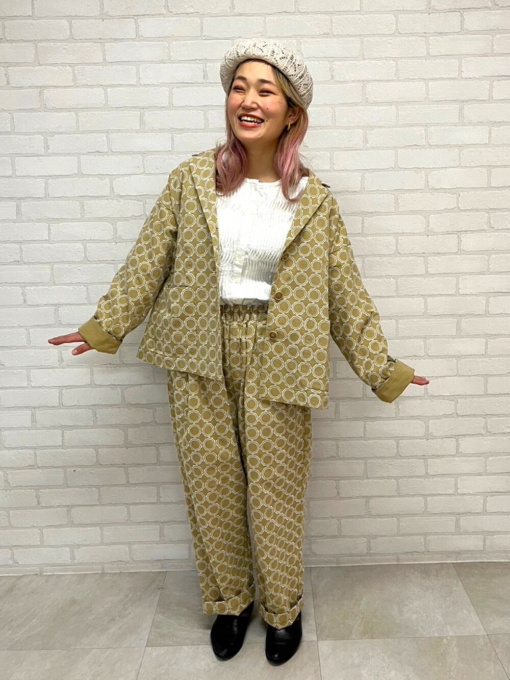 ベージュ系のパンツ、ベージュ系のジャケット/アウター、ホワイト系の帽子を着用したレディースの冬コーディネートの2枚目の写真