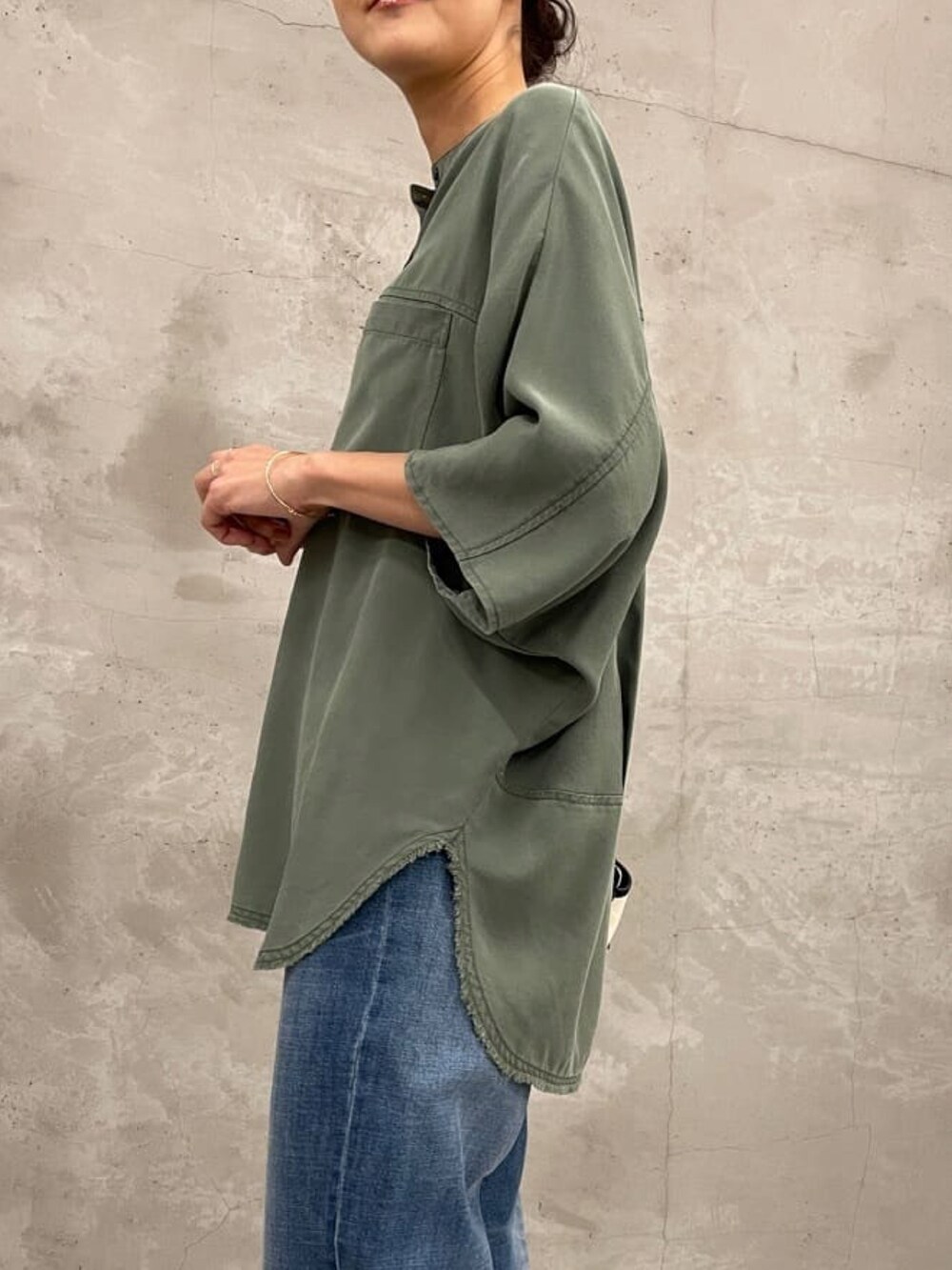 グリーン系のシャツ/ブラウス、ブラック系のショルダーバッグ、ブルー系のデニムパンツを着用したレディースの夏コーディネートの4枚目の写真