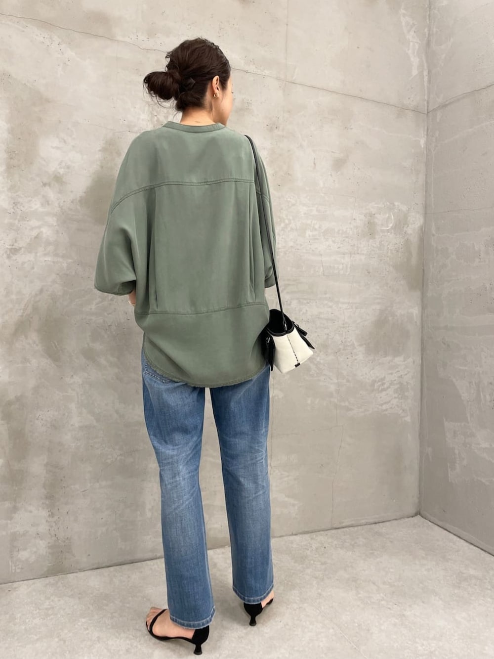 グリーン系のシャツ/ブラウス、ブラック系のショルダーバッグ、ブルー系のデニムパンツを着用したレディースの夏コーディネートの3枚目の写真