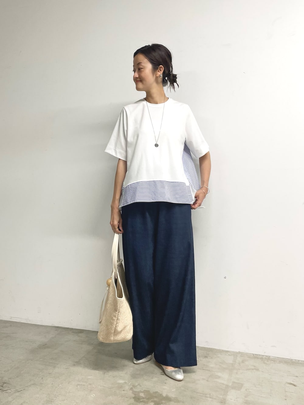 ホワイト系のTシャツ/カットソー、ブルー系のその他パンツ、ホワイト系のトートバッグを着用したレディースの夏コーディネートの2枚目の写真