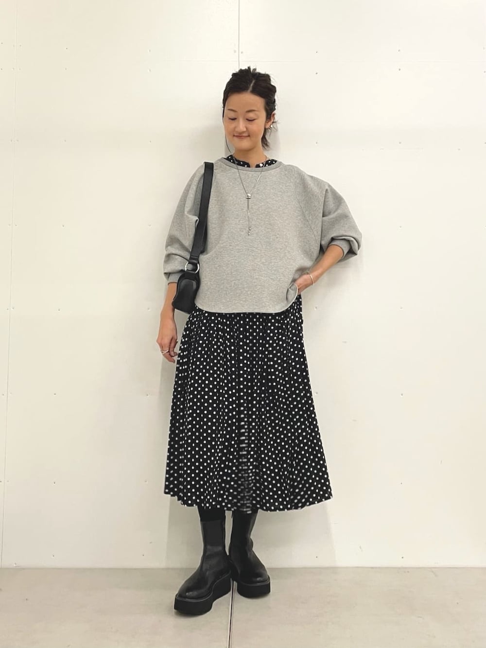 グレー系のTシャツ/カットソー、ブラック系のショルダーバッグ、ブラック系のワンピースを着用したレディースの秋コーディネートの4枚目の写真