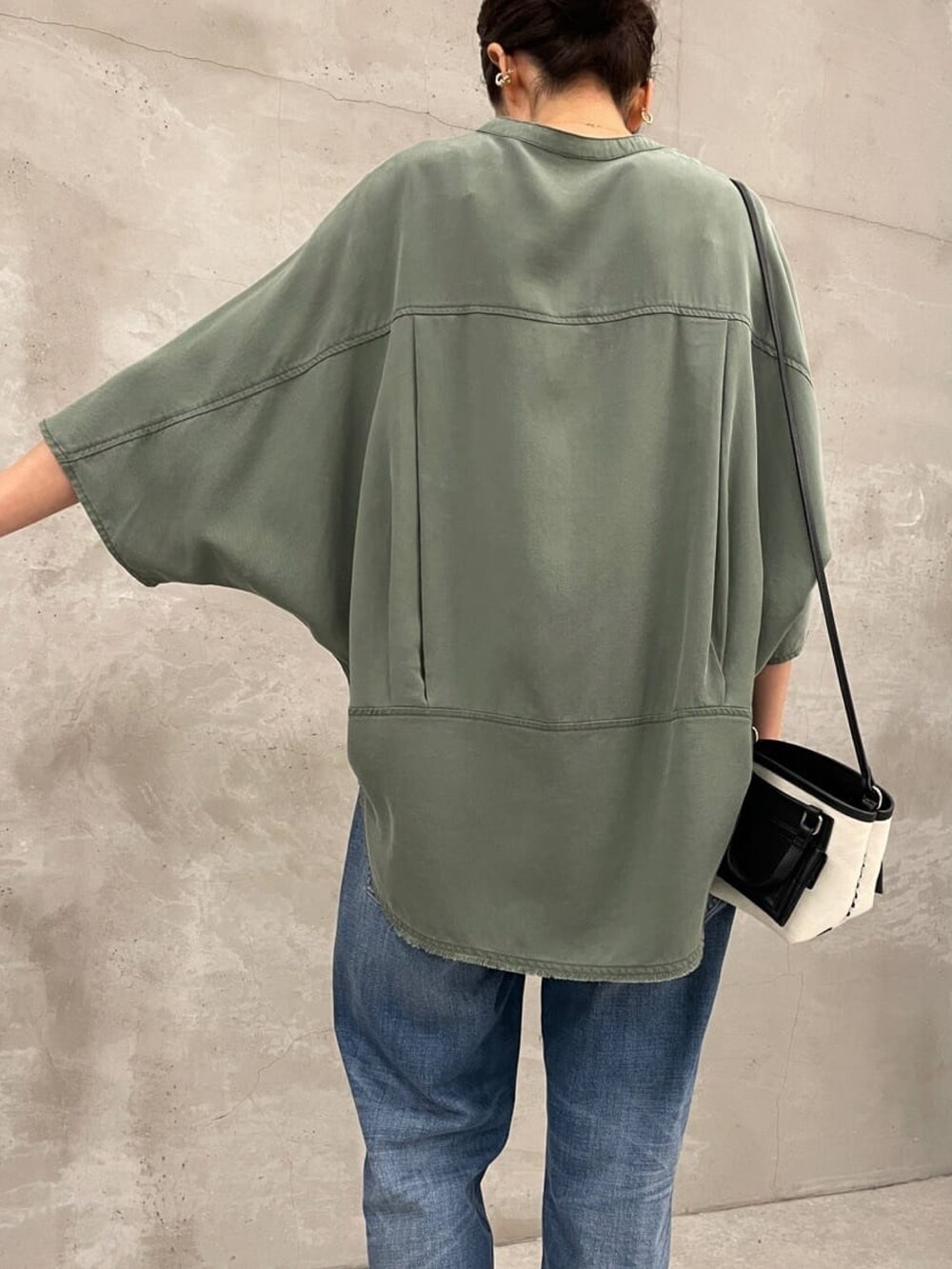 グリーン系のシャツ/ブラウス、ブラック系のショルダーバッグ、ブルー系のデニムパンツを着用したレディースの夏コーディネートの5枚目の写真