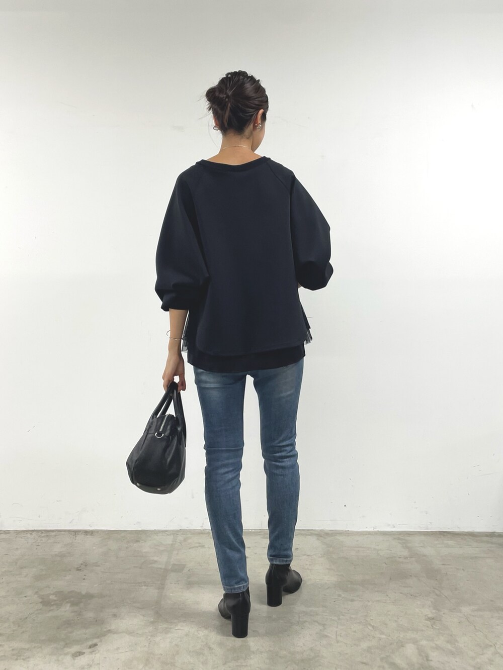 ブラック系のTシャツ/カットソー、ブラック系のキャミソール、ブルー系のデニムパンツを着用したレディースの秋コーディネートの3枚目の写真