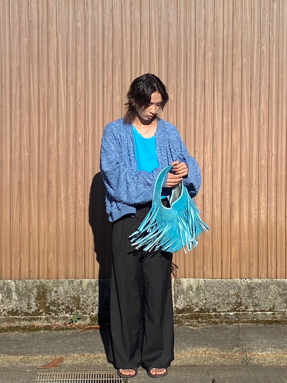 ブルー系のブルゾン、ブラック系のスラックス、ブルー系のタンクトップを着用したメンズの夏コーディネートの3枚目の写真