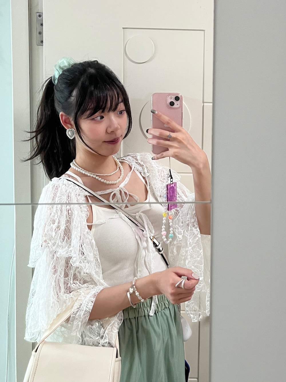 ホワイト系のキャミソール、ホワイト系のシャツ/ブラウス、グリーン系のスカートを着用したレディースの夏コーディネートの2枚目の写真