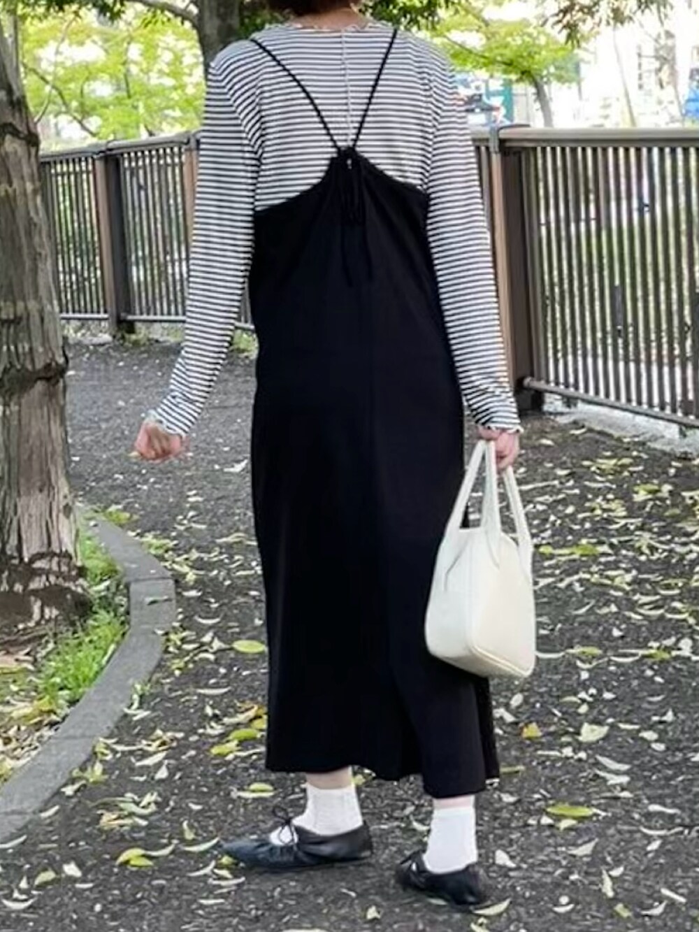 ホワイト系のTシャツ/カットソー、ブラック系のワンピース、ブラック系のバレエシューズを着用したレディースの春コーディネートの2枚目の写真