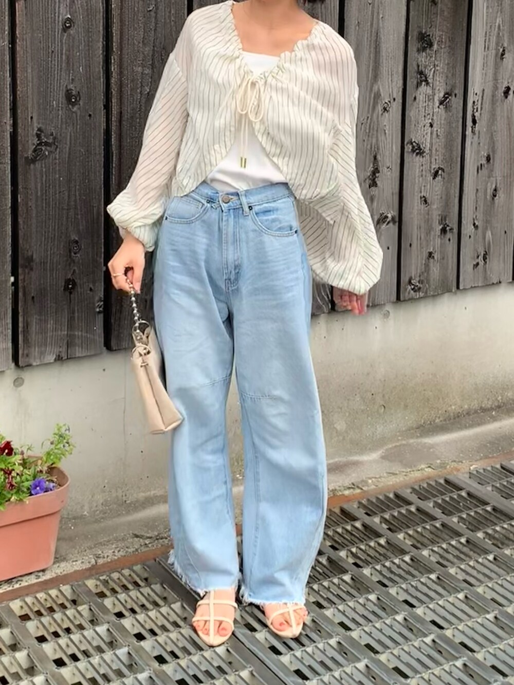 ベージュ系のシャツ/ブラウス、ブルー系のデニムパンツ、ホワイト系のショルダーバッグを着用したレディースの春コーディネートの2枚目の写真