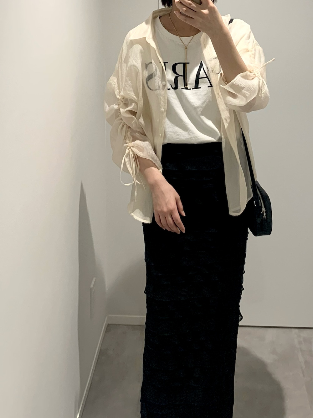 ホワイト系のシャツ/ブラウス、ブラック系のスカート、ブラック系のショルダーバッグを着用したレディースの春コーディネートの2枚目の写真