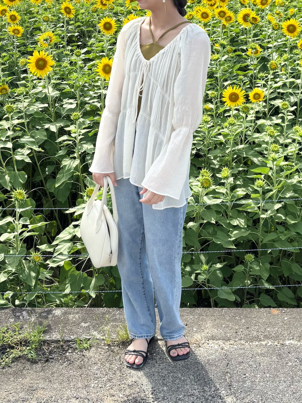 ホワイト系のシャツ/ブラウス、ブルー系のデニムパンツ、ホワイト系のショルダーバッグを着用したレディースの夏コーディネートの2枚目の写真