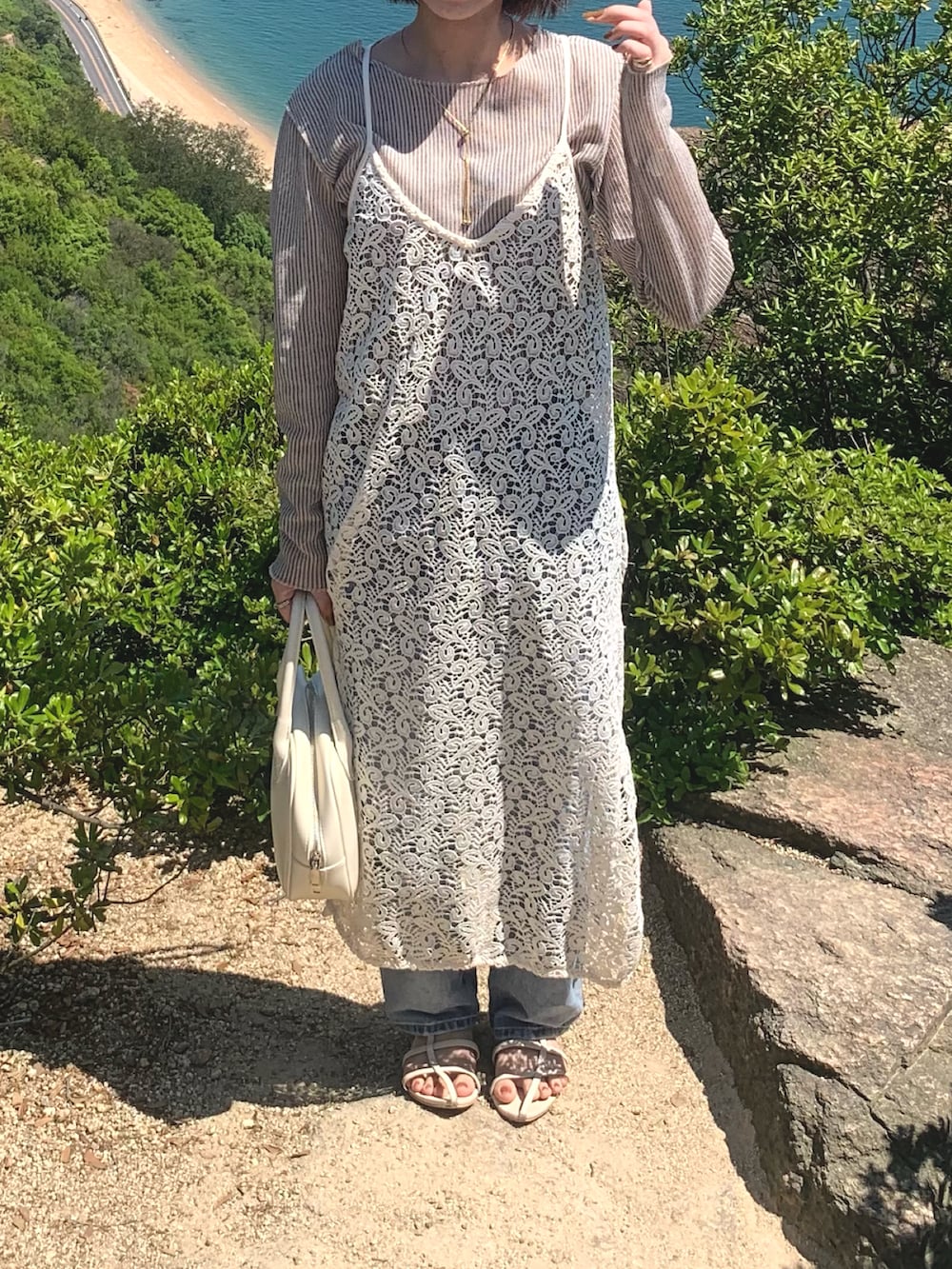 ホワイト系のTシャツ/カットソー、ホワイト系のワンピース、ブルー系のデニムパンツを着用したレディースの春コーディネートの2枚目の写真