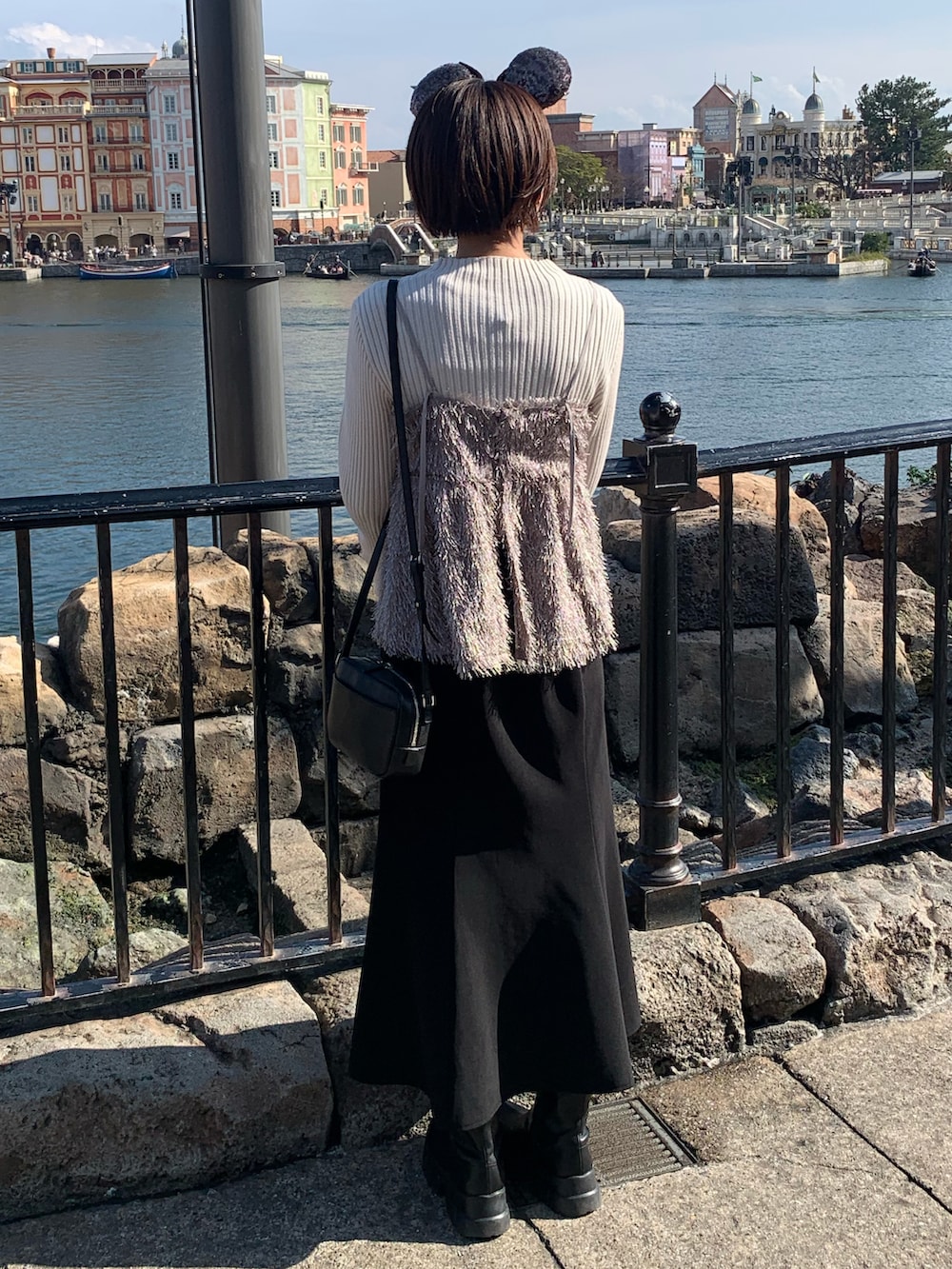 ホワイト系のニット/セーター、グレー系のキャミソール、ブラック系のスカートを着用したレディースの冬コーディネートの2枚目の写真