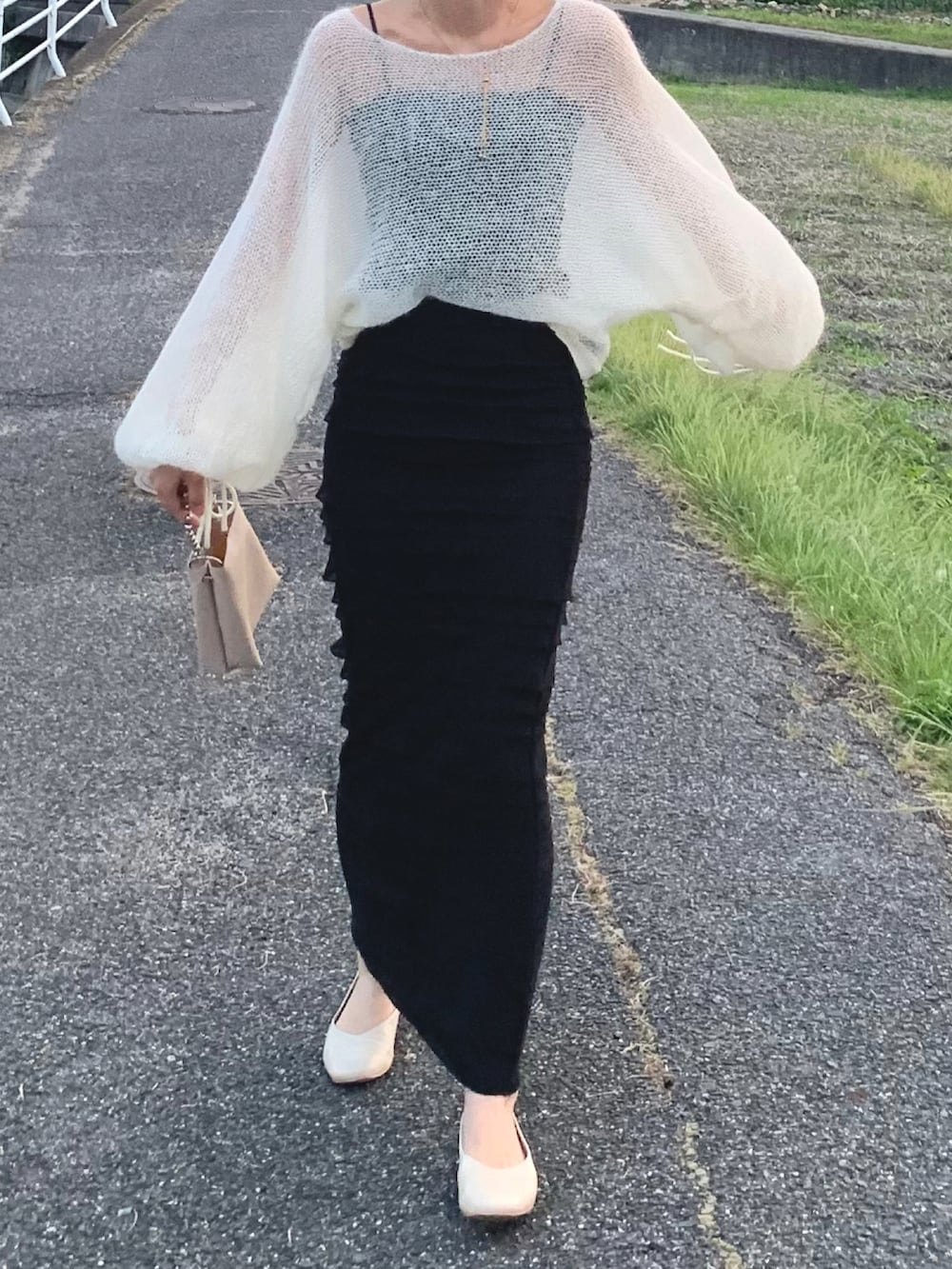 ホワイト系のニット/セーター、ブラック系のスカート、ホワイト系のバレエシューズを着用したレディースの夏コーディネートの2枚目の写真