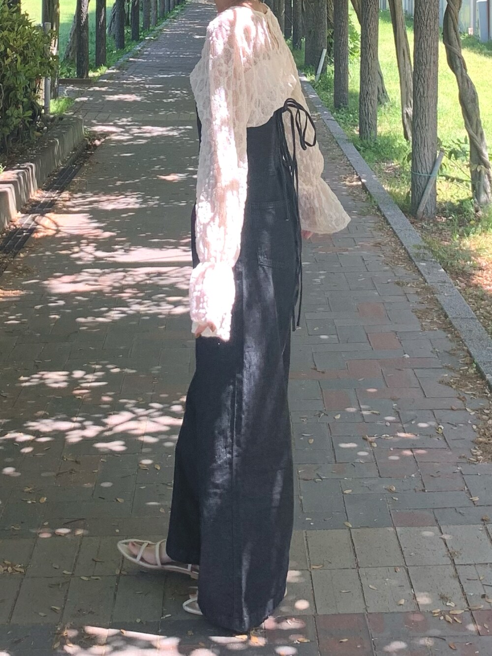 ホワイト系のTシャツ/カットソー、ブラック系のサロペット/オーバーオール、ホワイト系のサンダルを着用したレディースの春コーディネートの3枚目の写真