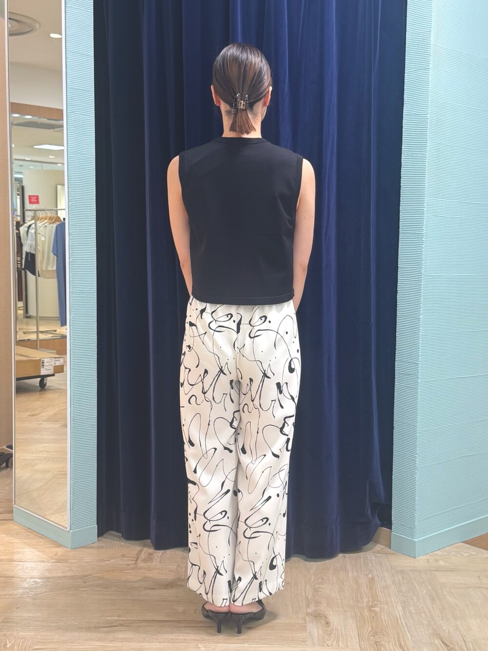 ホワイト系のその他パンツ、ブラック系のベスト、レッド系のバッグを着用したレディースの秋コーディネートの4枚目の写真