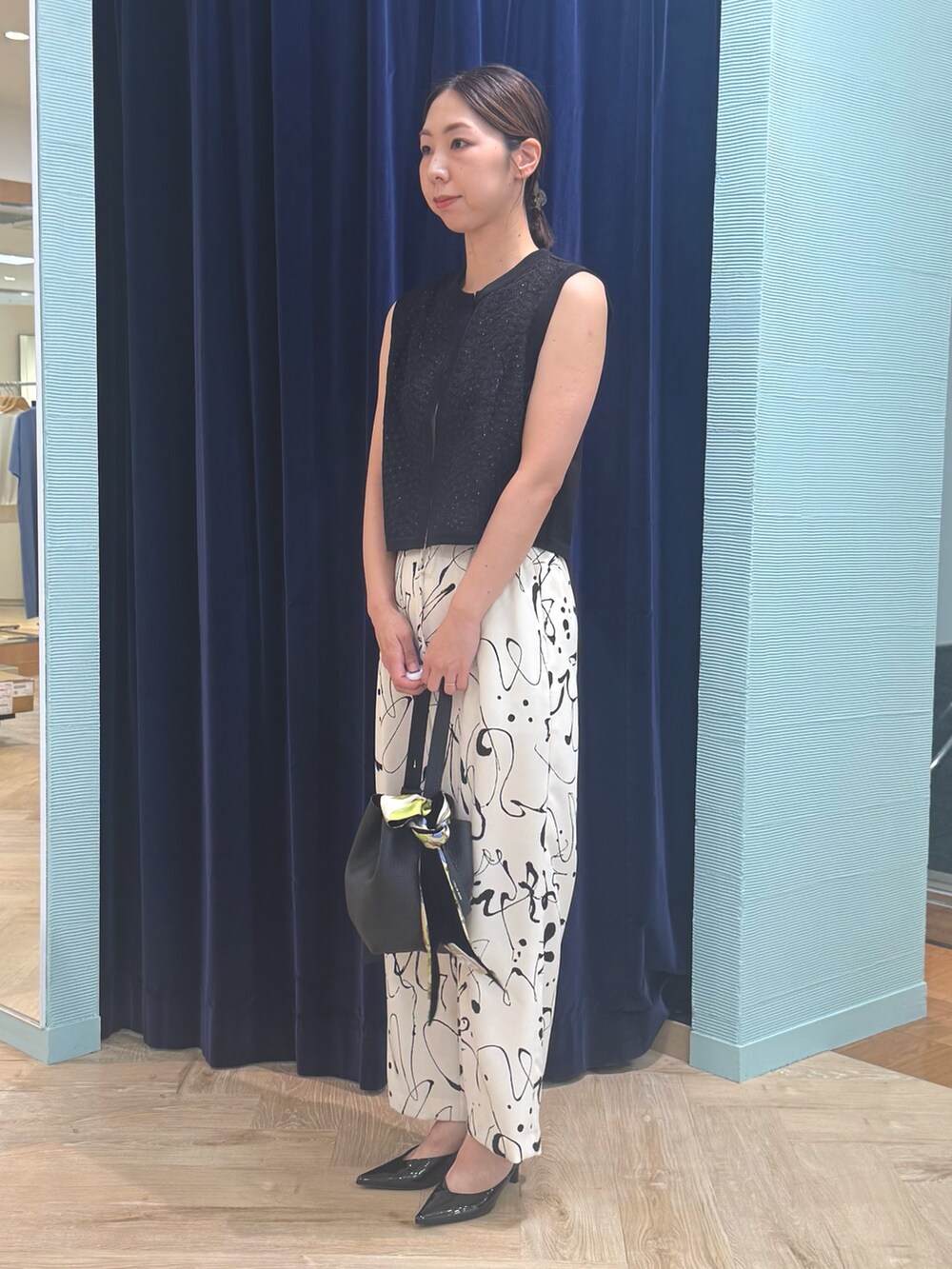 ホワイト系のその他パンツ、ブラック系のベスト、レッド系のバッグを着用したレディースの秋コーディネートの5枚目の写真