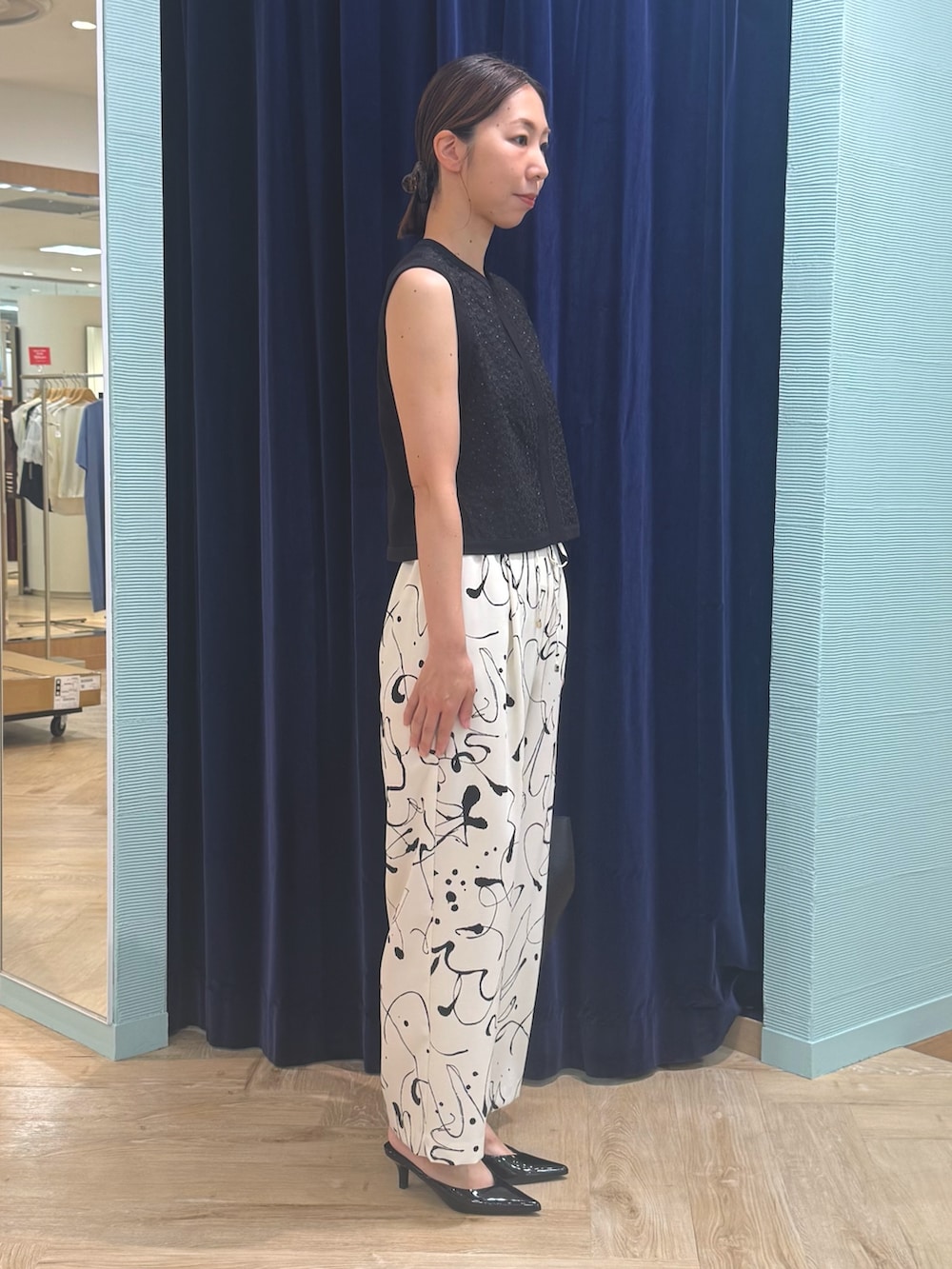 ホワイト系のその他パンツ、ブラック系のベスト、レッド系のバッグを着用したレディースの秋コーディネートの3枚目の写真