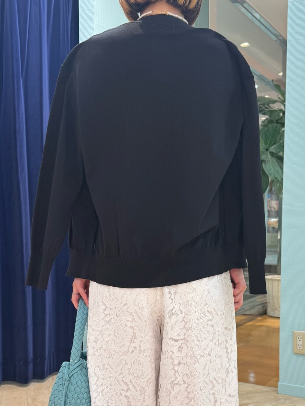 ブルー系のカーディガン/ボレロ、ホワイト系のその他パンツ、ブルー系のショルダーバッグを着用したレディースの春コーディネートの7枚目の写真