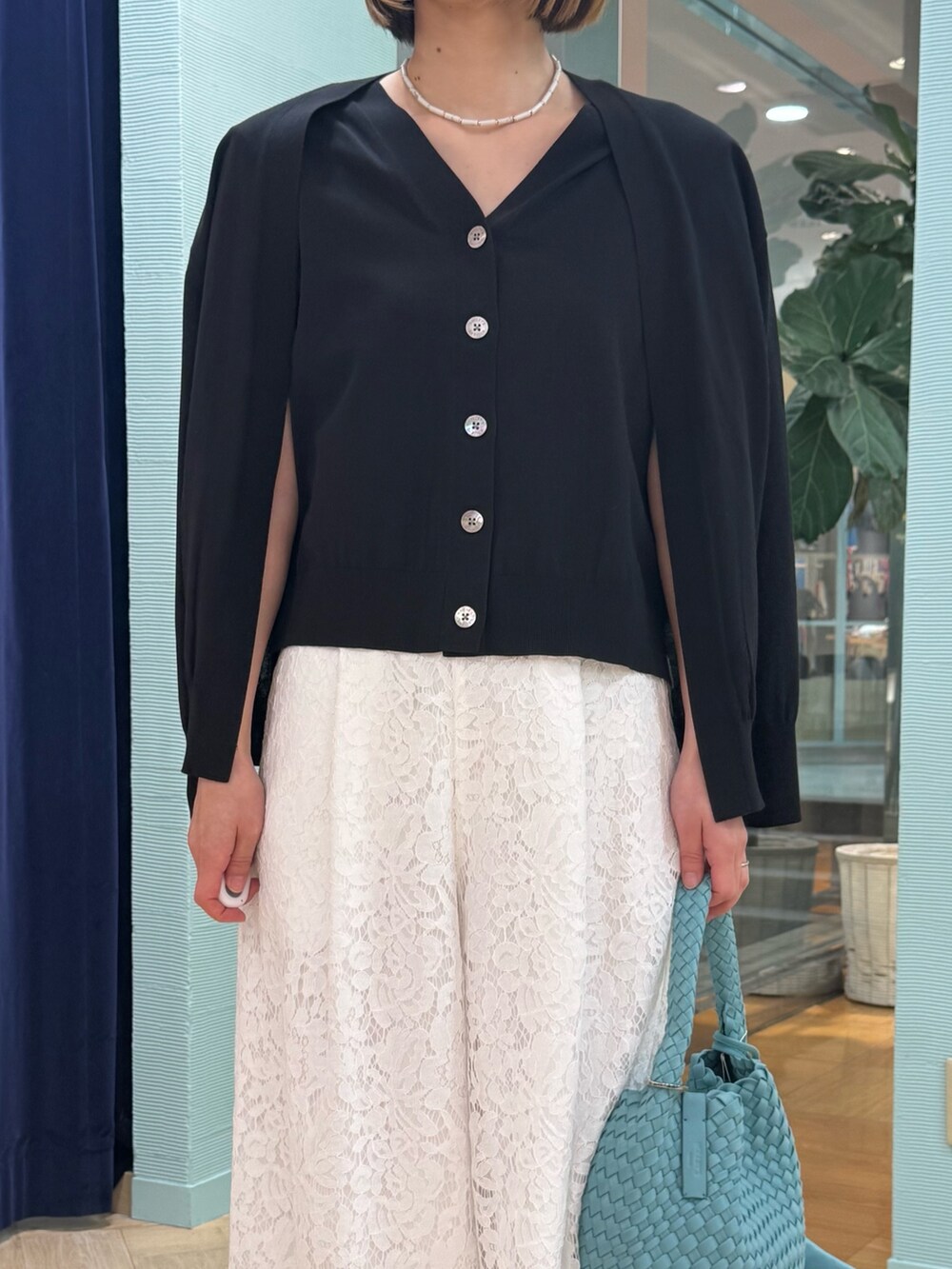 ブルー系のカーディガン/ボレロ、ホワイト系のその他パンツ、ブルー系のショルダーバッグを着用したレディースの春コーディネートの6枚目の写真