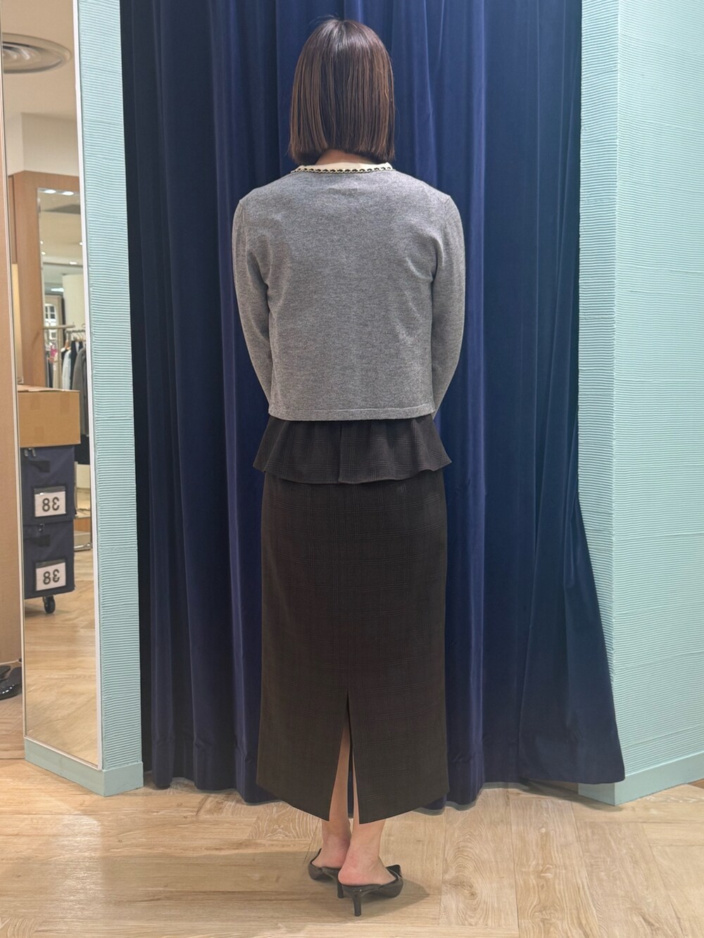 ベージュ系のスカート、グレー系のカーディガン/ボレロ、ブルー系のショルダーバッグを着用したレディースの秋コーディネートの4枚目の写真