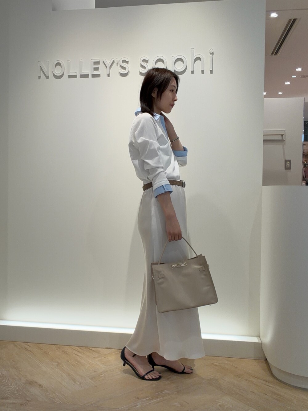 ホワイト系のニット/セーター、ホワイト系のスカート、ベージュ系のトートバッグを着用したレディースの春コーディネートの4枚目の写真