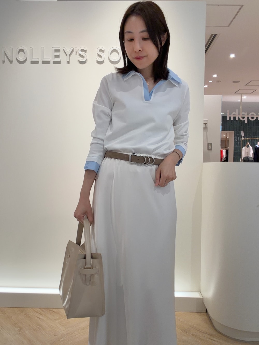 ホワイト系のニット/セーター、ホワイト系のスカート、ベージュ系のトートバッグを着用したレディースの春コーディネートの5枚目の写真