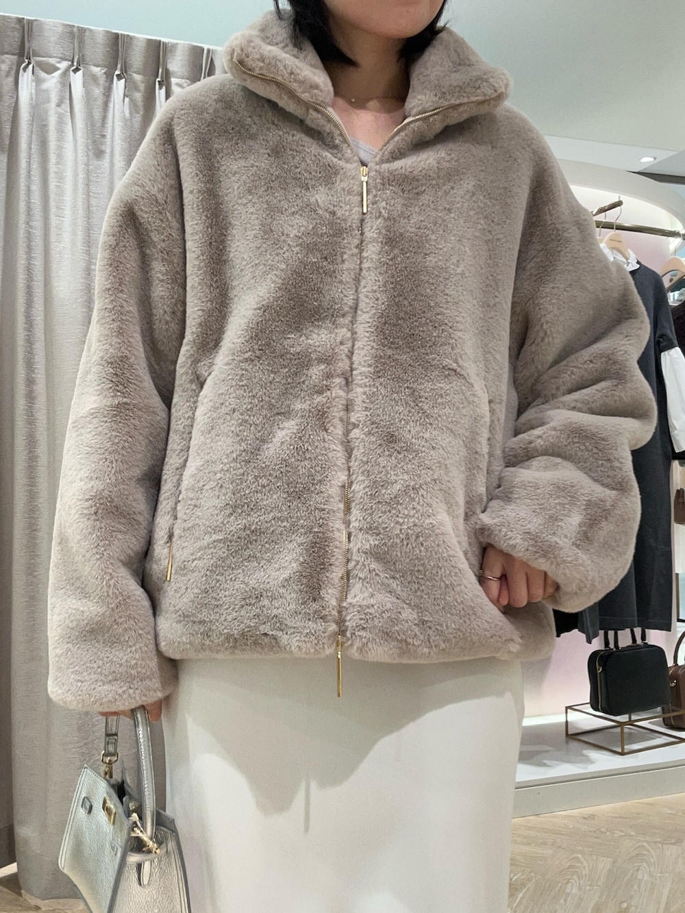 ベージュ系のTシャツ/カットソー、グレー系のブルゾン、シルバー系のショルダーバッグを着用したレディースの秋コーディネートの6枚目の写真