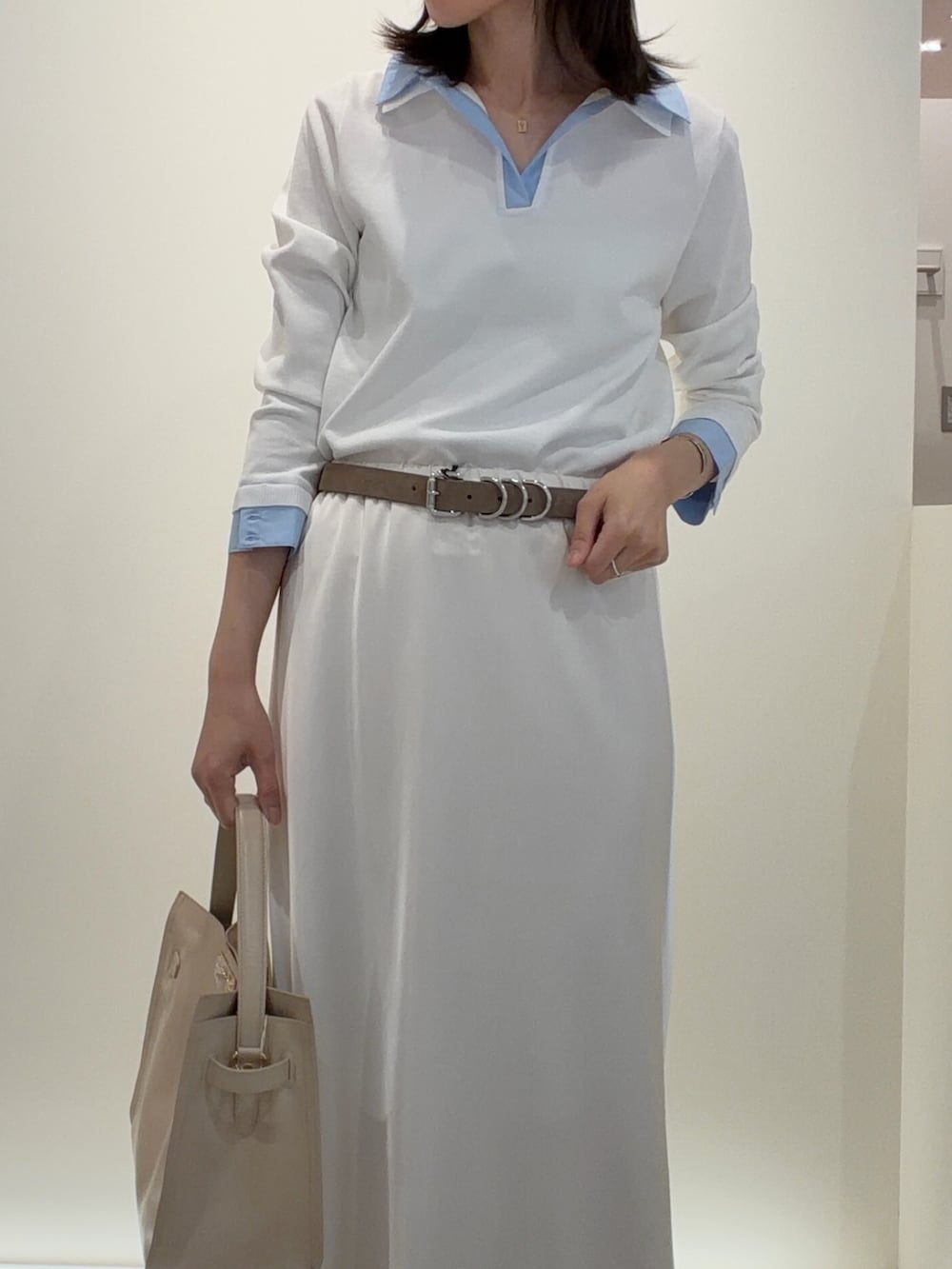 ホワイト系のニット/セーター、ホワイト系のスカート、ベージュ系のトートバッグを着用したレディースの春コーディネートの7枚目の写真