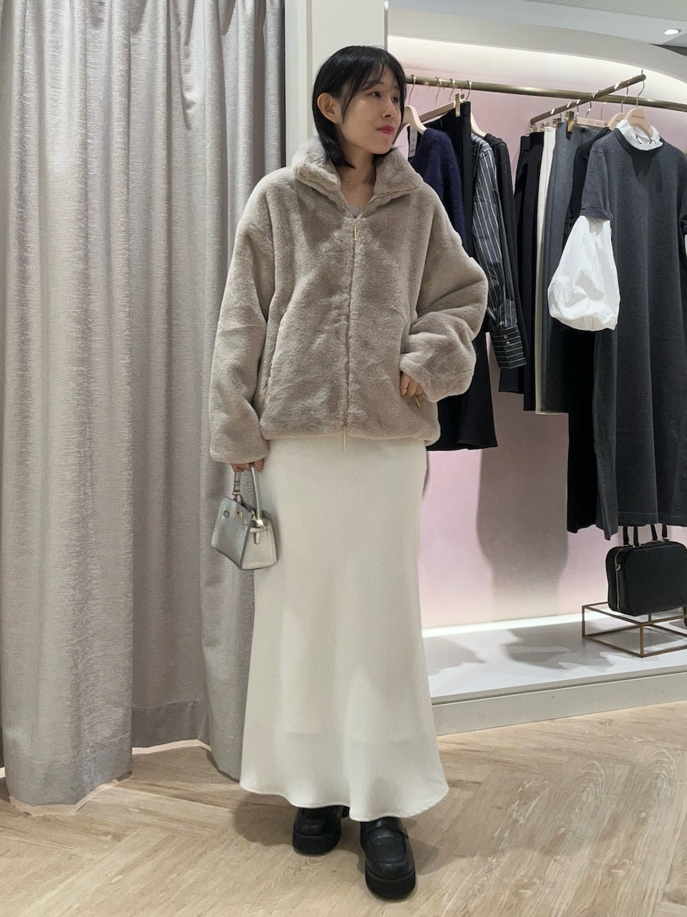 ベージュ系のTシャツ/カットソー、グレー系のブルゾン、シルバー系のショルダーバッグを着用したレディースの秋コーディネートの2枚目の写真