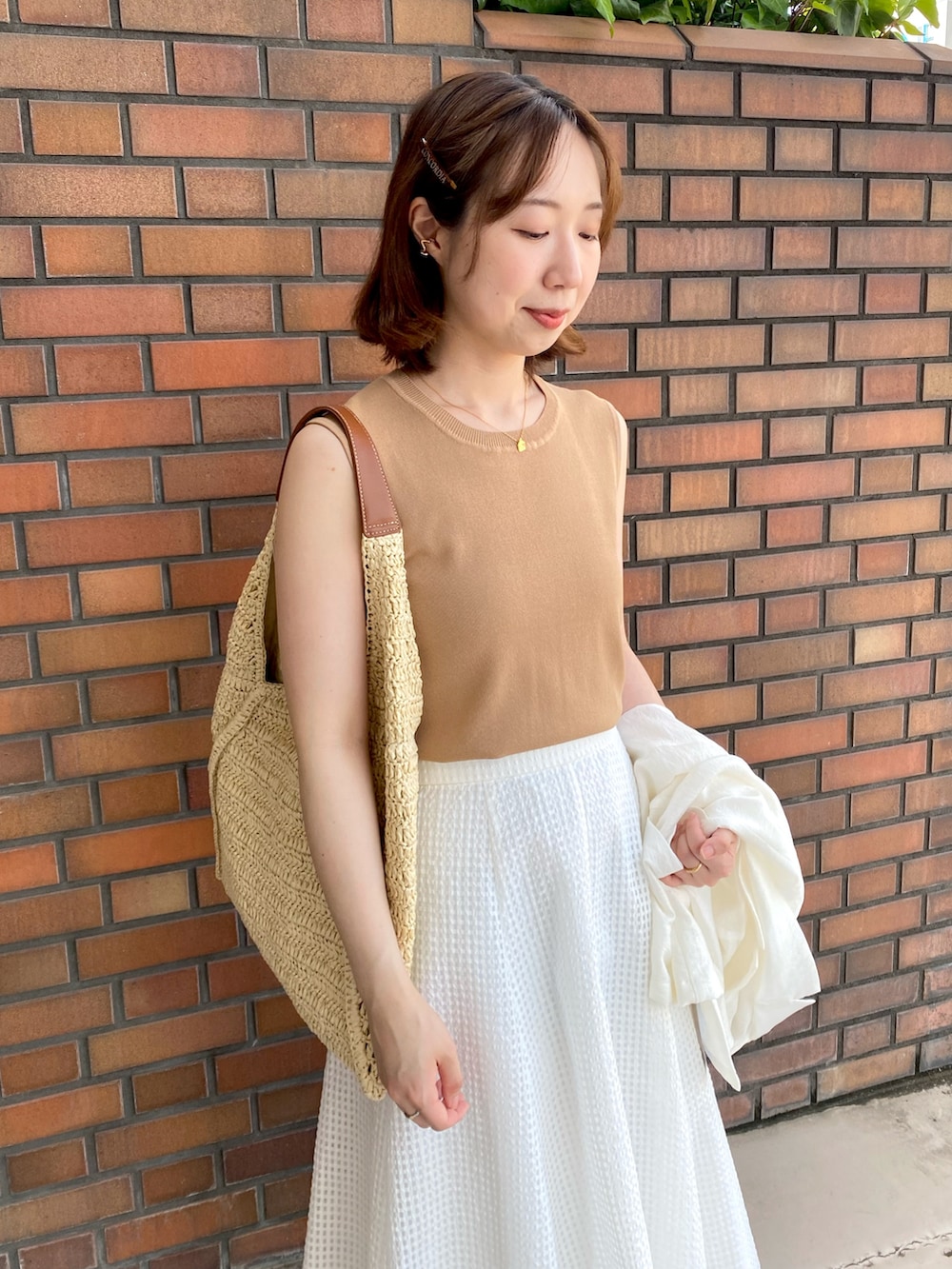 ホワイト系のテーラードジャケット、イエロー系のカーディガン/ボレロ、イエロー系のニット/セーターを着用したレディースの夏コーディネートの3枚目の写真