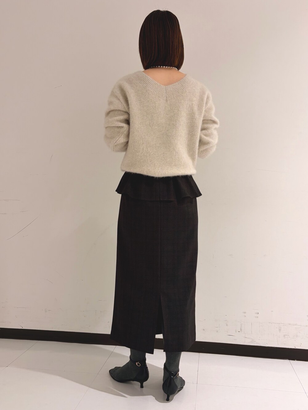 ベージュ系のニット/セーター、ベージュ系のスカートを着用したレディースの秋コーディネートの3枚目の写真